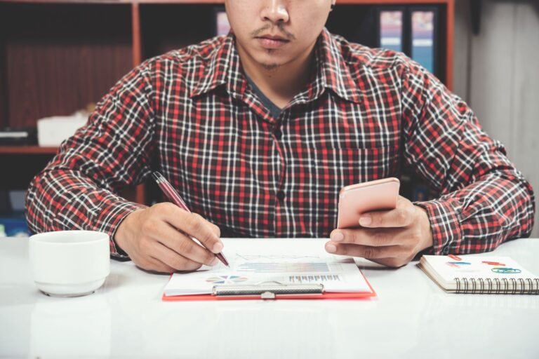 close-up-young-man-working-smart-phone-laptop