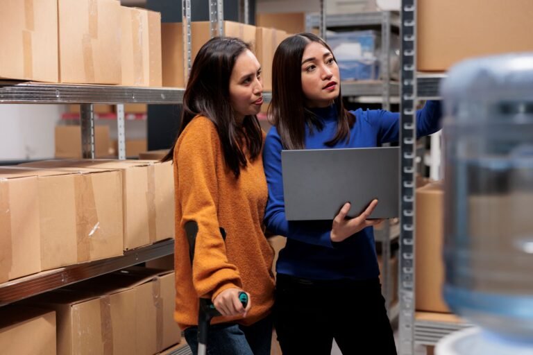 warehouse-managers-preparing-customer-order-checking-pick-ticket-laptop-storehouse-young-asian-women-employees-searching-parcel-shelf-while-using-inventory-software